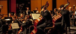 Photo d’un orchestre symphonique en pleine performance, illustrant la puissance d’un ensemble classique.